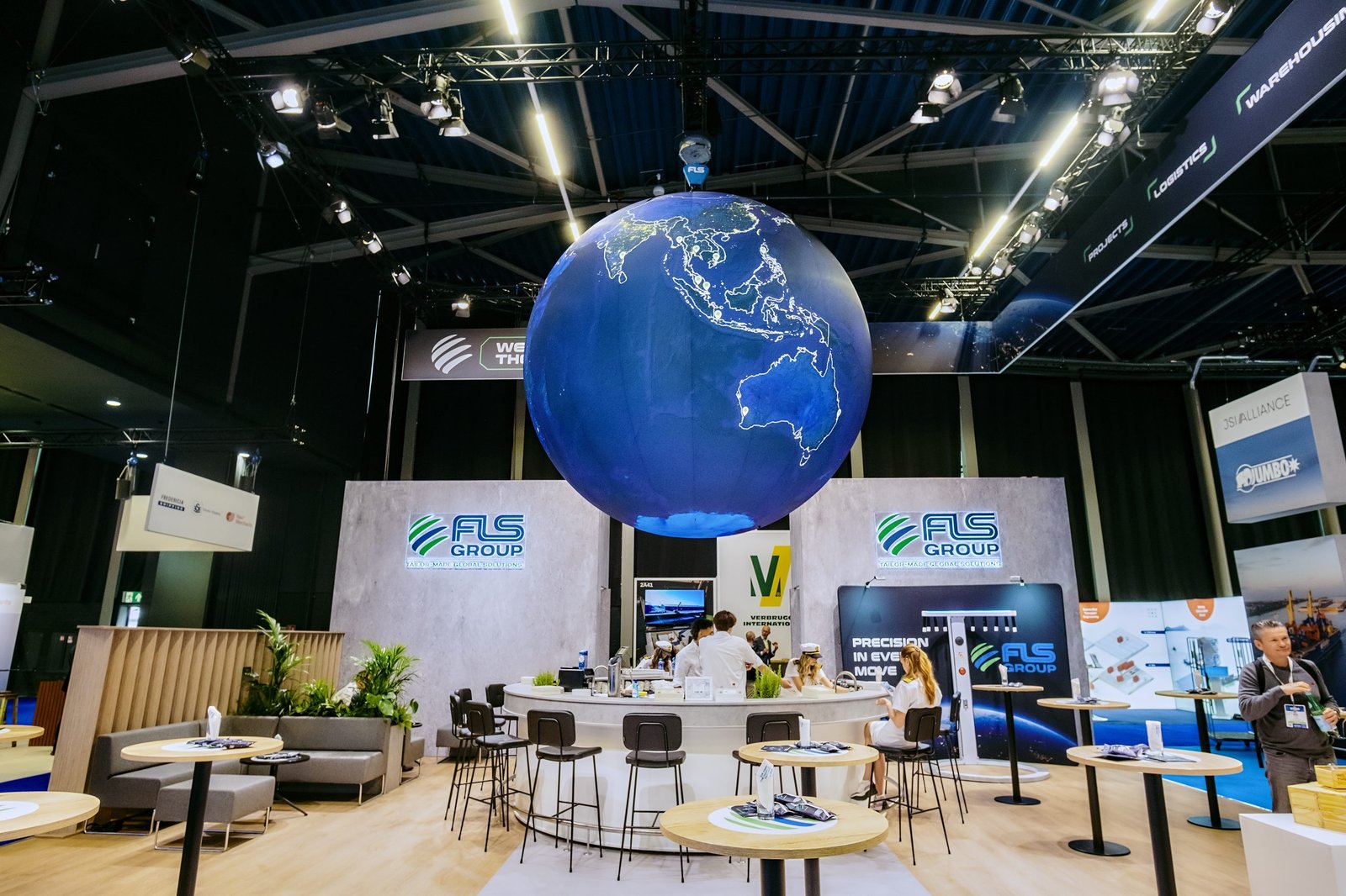 FLS Group booth hospitality area beneath the suspended globe