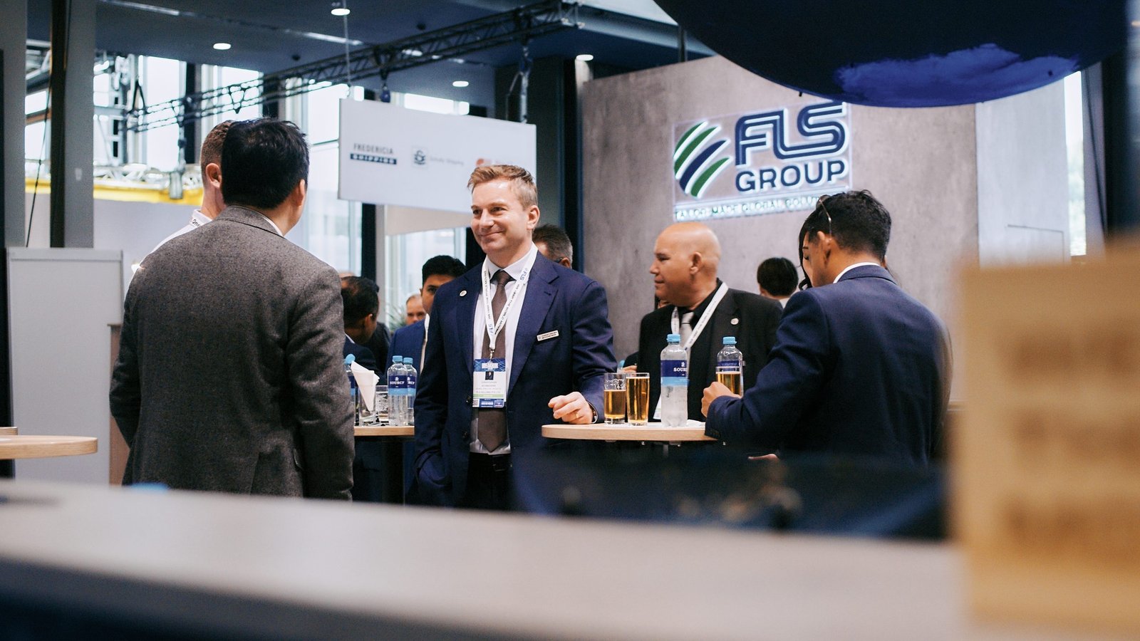 Attendees networking in front of the FLS Group booth